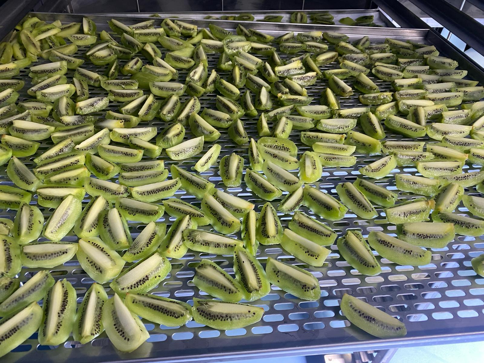 Peeled kiwi wedges on a perforated drying rack